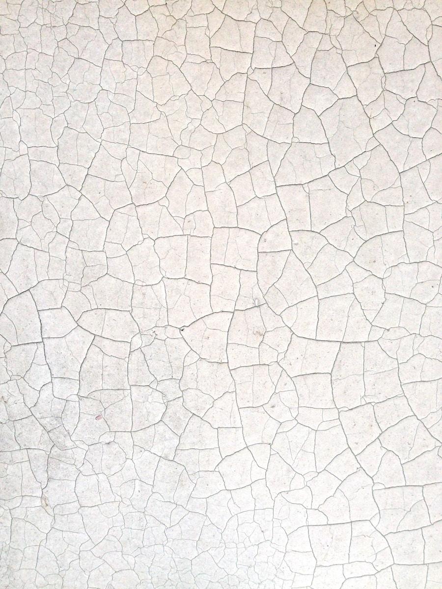 a close up of a white wall with cracks in it